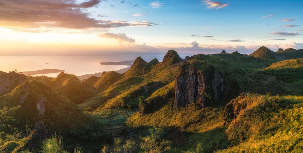 green hills and rocky limestone spires of Osmeña Peak during sunset in Dalaguete, Cebu, Philippines.